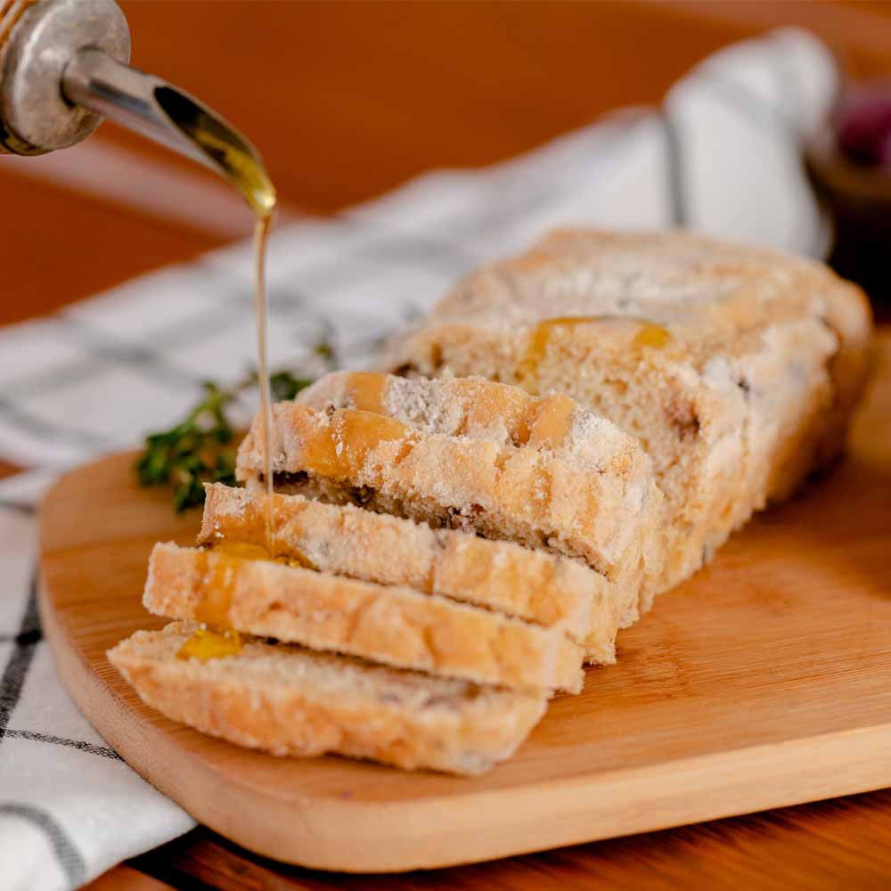 Pao-ciabatta-sabor-azeitonas-pretas-cortado-em-fatias-encima-de-uma-tabua-de-madeira-com-azeite